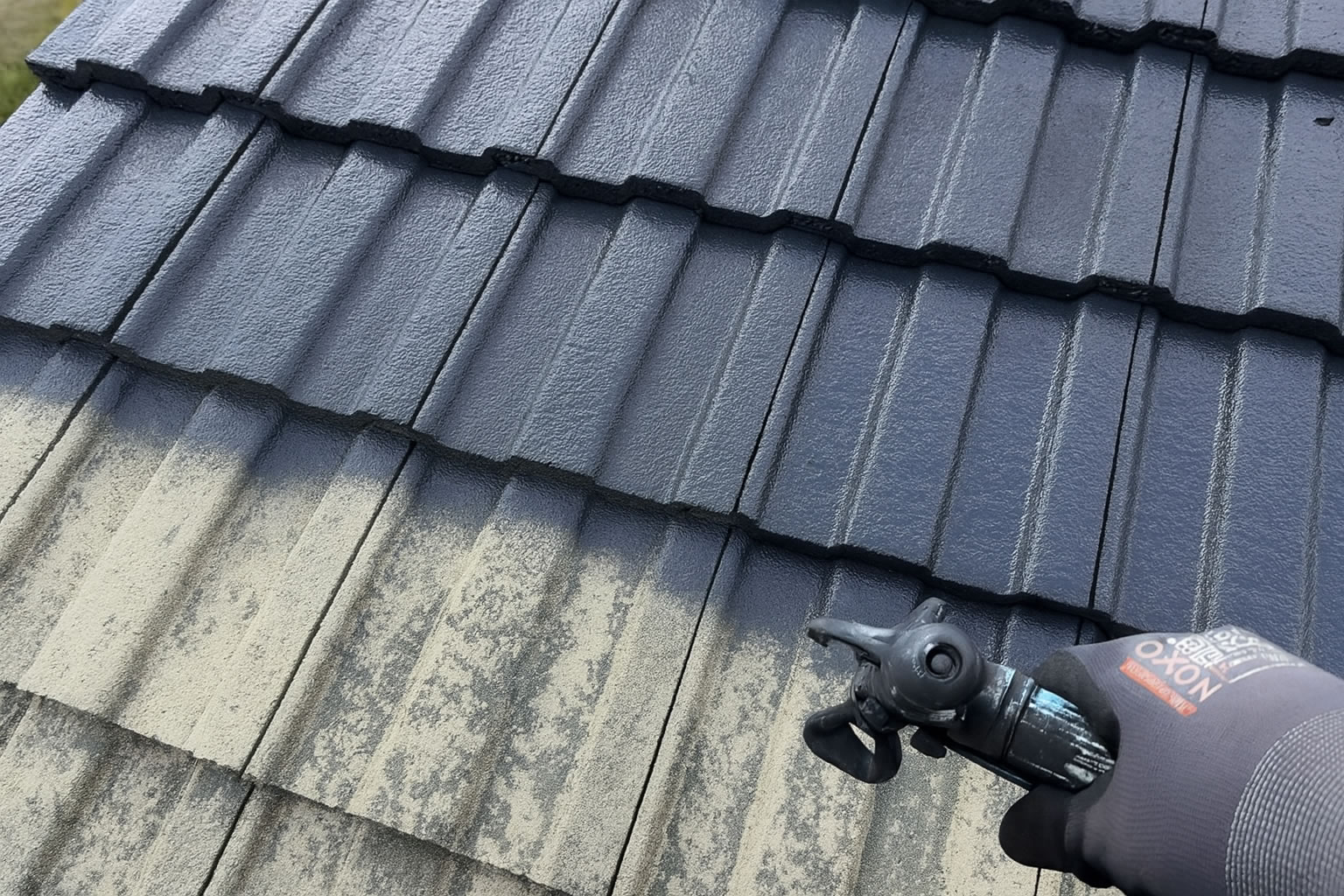 Roof being spray coated with protective paint on a Scottish home